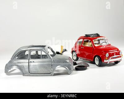Miniatur-Fiat-500-Nachbildung und Modellauto-Montagekonzept auf weißem Studiohintergrund Stockfoto