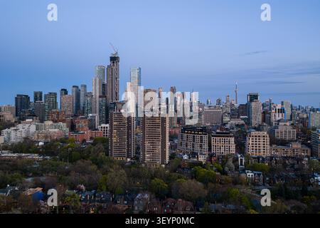 Die Skyline von Toronto mit den Hochhäusern der Innenstadt, dem CN Tower in der Ferne, dem blauen Abendhimmel, dem dichten Stadtteil am Wasser und modernen Bürogebäuden Stockfoto