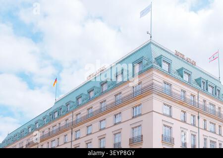 Berlin, Deutschland: Historisches Luxushotel Adlon Kempinski Fassade mit Kupferdach und deutscher Flagge am Pariser Platz, ikonische europäische Stadtarchitektur. Stockfoto