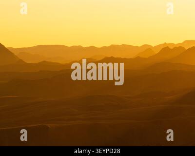Blick aus der Vogelperspektive auf die Thorsmork Bergkette bei Golden Hour mit geschichteten Silhouetten und warmem Licht in Rangarthing Eystra, Island. Stockfoto