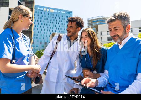 Diverse Ärzteteams diskutieren vor dem Krankenhaus Stockfoto
