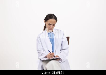 Wissenschaftlerin macht Notizen in Laborjournal auf einem professionellen Foto... Stockfoto