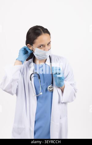 Ärztin passt ihre medizinische Schutzausrüstung im Studio an Stockfoto