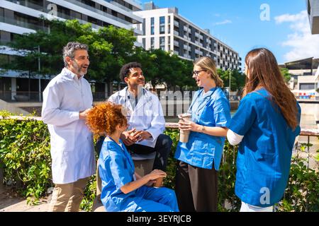 Vielfältige medizinische Fachkräfte diskutieren Gesundheitsthemen im Freien Stockfoto