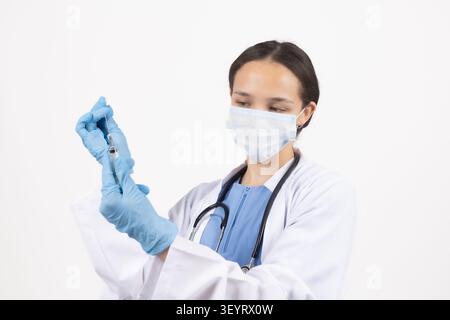 Medizinischer Fachmann, der eine Maske trägt, die Schutzausrüstung hält Stockfoto