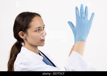 Wissenschaftlerin mit blauen Schutzhandschuhen in einer professionellen Fotostudi... Stockfoto