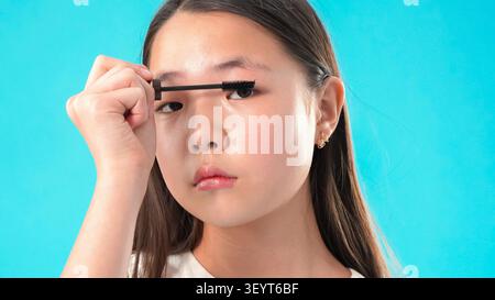 Junge Frau, die im Studio Make-up mit Pinsel aufträgt Stockfoto