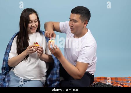 Junges Familienpaar frühstückt im Küchenbett auf einem professionellen Foto... Stockfoto