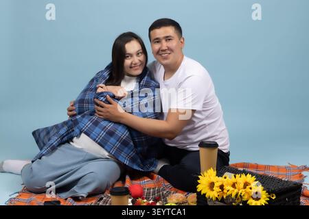 Romantisches Paar, das bei einem Picknick unter einer warmen Decke sitzt Stockfoto