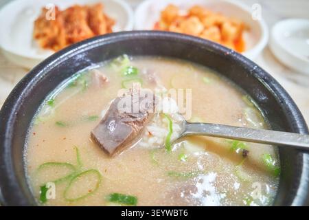 Herzhafte asiatische Rindfleischsuppe in einer Ton Schüssel mit dickem Fleisch und Reis. Serviert mit Beilagen, die ein authentisches, tröstendes lokales Esserlebnis einfangen. Stockfoto