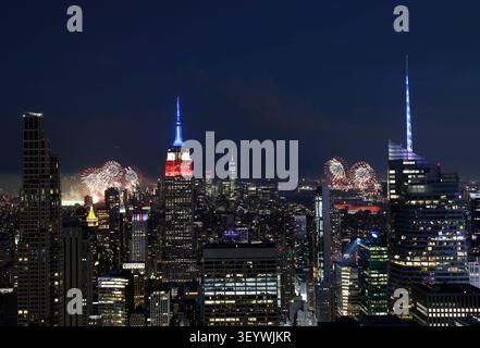 New York, United States. 04th July, 2026. The Empire State Building is lit in red, white and blue as the Macy's 4th of July fireworks light up the night sky as part of the celebration of America's 250th anniversary as seen From the Top of the Rock Observation Deck at Rockefeller Center in New York City on Saturday, July 4, 2026. Photo by John Angelillo/UPI Credit: UPI/Alamy Live News Stockfoto