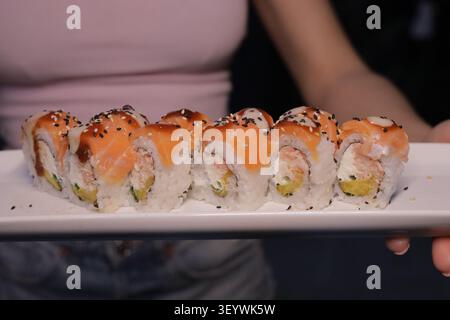 Lachs-Sushi-Rollen auf weißem Teller, Nahaufnahme Stockfoto
