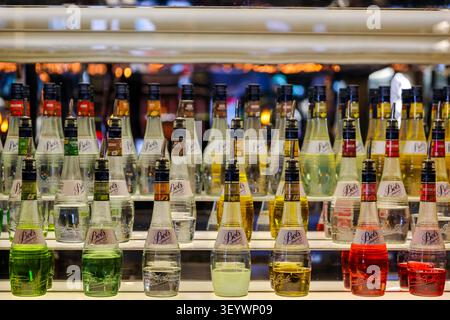 Farbenfrohe Darstellung von Bols-Likörflaschen im House of Bols Cocktail Experience in Amsterdam, Niederlande. Stockfoto