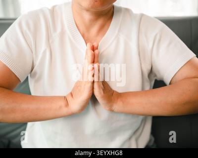 Nahaufnahme von asiatischen Frauenhänden in Gebetsposen während der Meditation zu Hause, Konzept der Achtsamkeit, des ruhigen Geistes, des Wohlbefindens, der Spiritualität, Dankbarkeit, Frieden, A Stockfoto