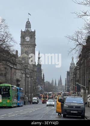 Belebte Straßensicht entlang der Princes Street mit dem ikonischen Uhrturm des Balmoral Hotels und Doppeldeckerbussen, Edinburgh Stockfoto