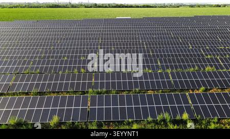 Solarfarm mit Reihen von Photovoltaikpanelen, die saubere Energie erzeugen, und zeigt nachhaltige Stromerzeugung auf einem grünen Feld Stockfoto