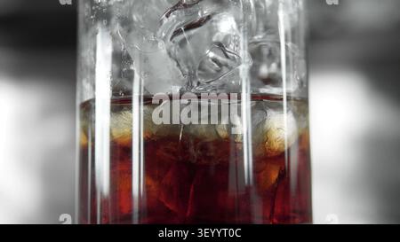 Glas mit eiskaltem Cold Brew Kaffee mit Kondensation und Eiswürfeln, ein erfrischendes dunkles Getränk im Nahaufnahme Stockfoto