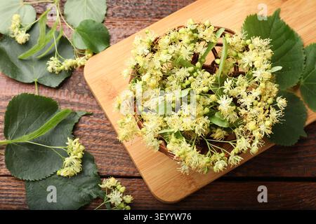Lindenbaum blüht im Korb auf Holztisch, flach gelegt Stockfoto