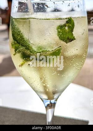 Nahaufnahme eines kalten Hugo Spritz Cocktails mit Minze- und Holunderblütensirup in einem Weinglas Stockfoto