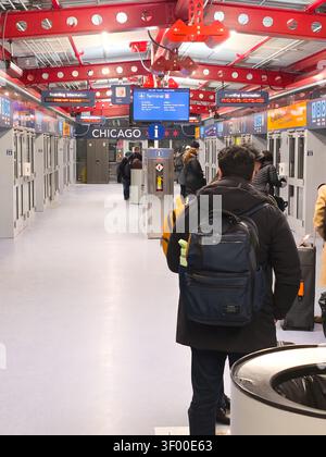 CHICAGO, IL, USA - 20. JANUAR 2026: Passagiere stehen am Flughafen Chicago mit digitalem Fluginformationsschild in der Schlange. Chicago O'Hare International Stockfoto