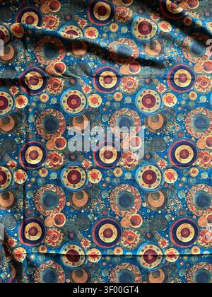 Lebendige konzentrische Kreise in satten Erdtönen und Indigo erzeugen ein dynamisches, verspieltes Muster auf diesem wunderschönen japanischen Stoff Stockfoto
