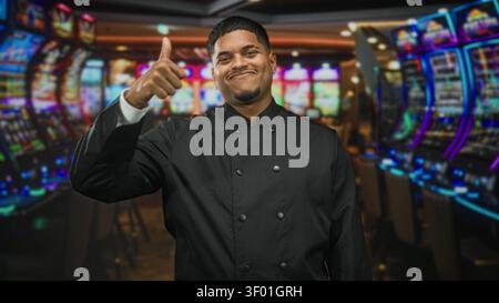 Hispanische Küchenchefin macht Friedenszeichen mit Hand und Fingern in einem Kasino-Gebäude; Selbstvertrauen-Feier. Stockfoto