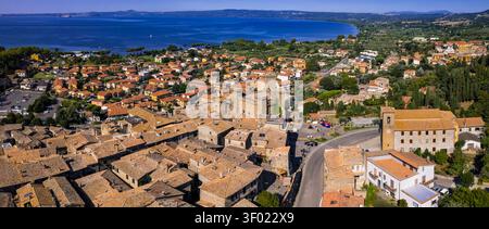 Panoramablick auf Bolsena Stadt mit mittelalterlicher Burg, alter Kirche und vulkanischem See, Latium, Italien Ultra hochauflösendes Foto von oben. Welt prin Stockfoto