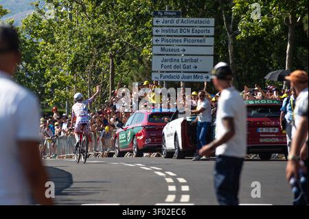 BARCELONA, SPANIEN - 5. JULI 2026: Tadej Pogacar vom Team Emirates der Vereinigten Arabischen Emirate, trägt das Polka-Dot-Trikot und bejubelt die Fans nach der 2. Etappe der Tour de France auf dem Hügel Montjuic in Barcelona, Spanien, am 5. Juli 2026. Der slowenische Radfahrer fährt an offiziellen Skoda-Team- und Organisationsautos vorbei, während die Menge an den Straßensperren applaudiert. Im Hintergrund sind markante Straßenschilder in Barcelona zu Fundacio Joan Miro und Piscines Picornell zu sehen. Quelle: Claudio Perrone/Alamy Live News Stockfoto