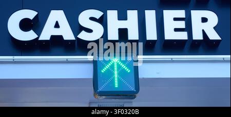 CARROLLTON, TX, USA - 24. FEBRUAR 2024: Ein großes Kassiererschild ist gut sichtbar mit einer grünen LED-Pfeilleuchte, die einen offenen Zähler anzeigt, suggt Stockfoto