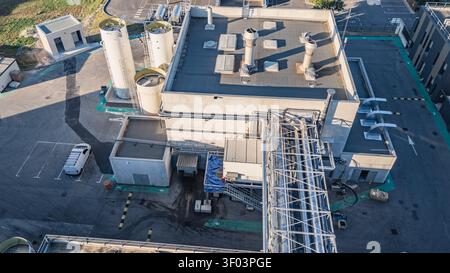 Luftaufnahme einer industriellen Verarbeitungsanlage mit Dachlüftung, Lagertanks und komplexer Rohrleitungsinfrastruktur im Werksgelände in Stockfoto