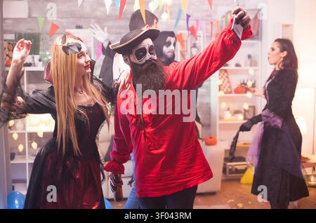 Junge Männer und Frauen in Halloween-Kostümen machen gemeinsam ein Selfie, um ein lustiges, saisonales Partyporträt zu kreieren, das Monster-Kostüme und soziale Interaktion kombiniert. Stockfoto