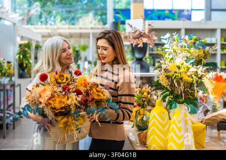 Frauen genießen zusammen ein wunderschönes Blumenarrangement im Blumenladen Stockfoto