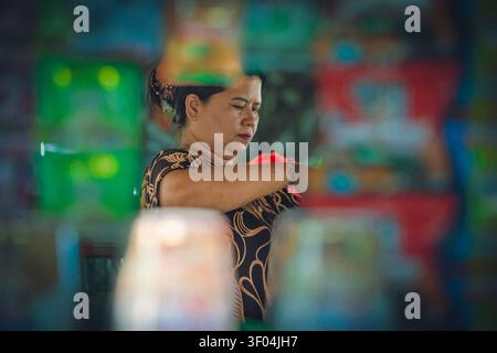 Ein natürliches Porträt einer Frau, die in einer Warung auf Bali arbeitet Stockfoto