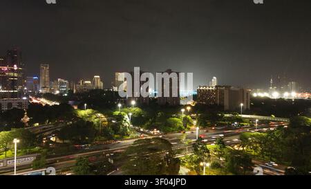 Luftaufnahme der Semanggi Kreuzung mit beleuchteten Wolkenkratzern und starkem Verkehr bei Nacht in Kecamatan Setiabudi, Daerah Khusus Ibukota, Indones Stockfoto