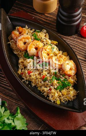 In der Pfanne gebratene Garnelen, serviert über köstlichem gebratenem Reis Stockfoto