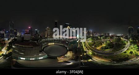 Blick aus der Vogelperspektive auf die Plaza Semanggi und die beleuchtete Kreuzung Semanggi bei Nacht, umgeben von der glitzernden Skyline von Jakarta in Kecamatan Setiabudi Stockfoto