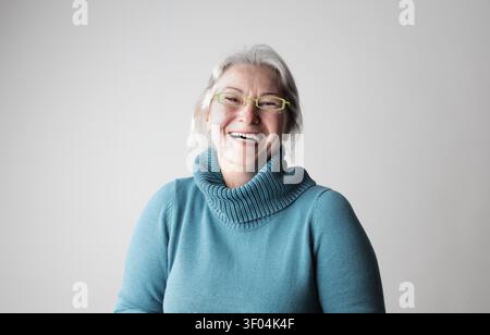 Glückliche Seniorin mit grauen Haaren, die lachen Stockfoto