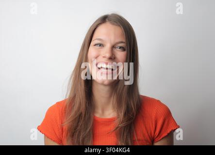 Glückliche junge Frau mit einem großen, schönen Lächeln Stockfoto