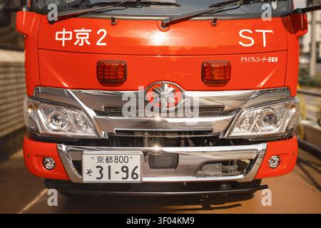 Symmetrische Nahansicht des Kühlergrills, der Scheinwerfer und des amtlichen Kennzeichens eines hellroten Feuerwehrkraftwagens, Kyoto, Japan Stockfoto