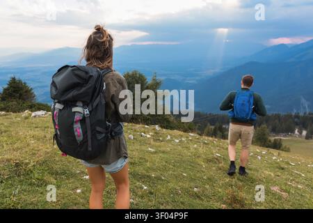 Zwei Personen wandern in einer Berglandschaft mit Rucksäcken. Sie erkunden die Wanderwege und genießen die Aussicht. Stockfoto