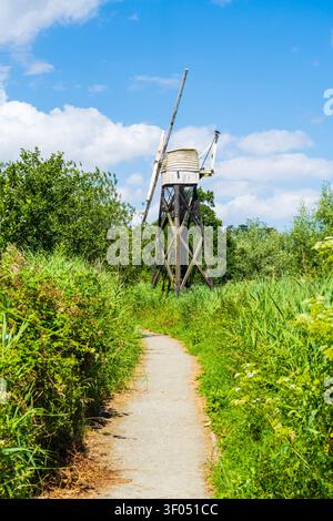 Weg zum Entwässerungsmühle Boardman nahe Ludham in North Norfolk, UK. Eine Holzmühle mit offenem Rahmen, eine der wenigen, die noch auf den Broads übrig sind, im Porträt Stockfoto
