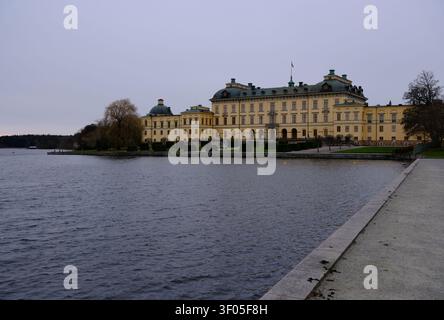 Stockholm, Schweden-27. Nov. 2025: Weitwinkelansicht des Drottningholm-Schlosses in Schweden an einem bewölkten Tag, historisches Gebäude am Wasser. Stockfoto