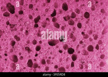 Makro, Nahaufnahme einer rosa Schaumschwammtextur mit poriger, schwammiger und blasiger Oberflächenstruktur, geeignet für abstrakte Hintergründe. Geschäumtes Polyurethan Stockfoto