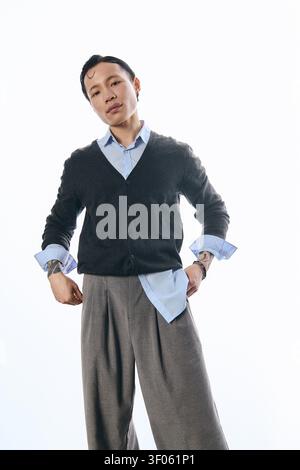 Ein selbstbewusster junger asiatischer Mann in trendiger Kleidung posiert mit Charme und Stil. Stockfoto