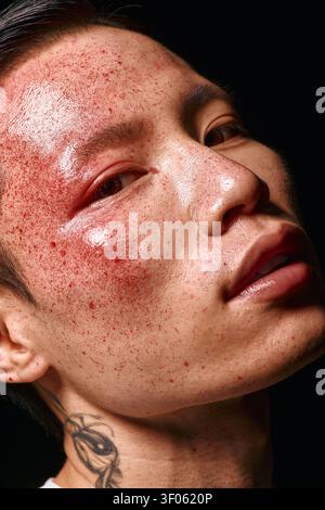 Ein stilvoller junger Mann mit auffälligen Funktionen zeigt selbstbewusst moderne Mode bei weichem Licht. Stockfoto