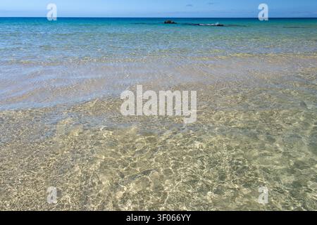 Klares flaches türkisfarbenes Wasser über Sand in Kaunaʻoa Bay auf der Big Island von Hawaii Stockfoto