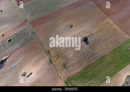 Luftaufnahme der Drohne auf Fleckenfelder und Feldwege in der Nähe von Guadalajara, Spanien, mit strukturiertem gepflügtem Land, Grünflächen und isoliertem tr Stockfoto