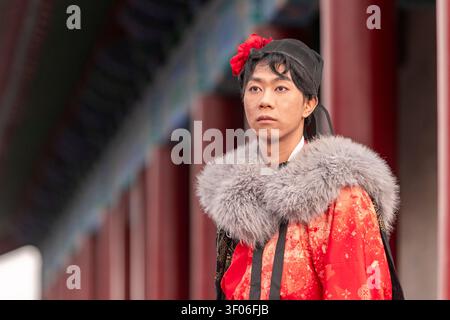 Ein junger chinesischer Mann mit traditionellem Hanfu und Pelzkragen steht in der Nähe der Xi’an Stadtmauer in China und zeigt traditionelle Mode, Kultur und Geschichte Stockfoto