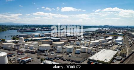 Eine Luftpanoramablick offenbart ein weitläufiges Petroleum- und Chemikalienlager neben einem geschäftigen industriellen Flusshafen im Pazifischen Nordwesten. Stockfoto