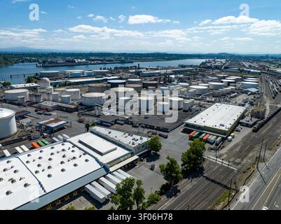 Eine Luftpanoramablick offenbart ein weitläufiges Petroleum- und Chemikalienlager neben einem geschäftigen industriellen Flusshafen im Pazifischen Nordwesten. Stockfoto